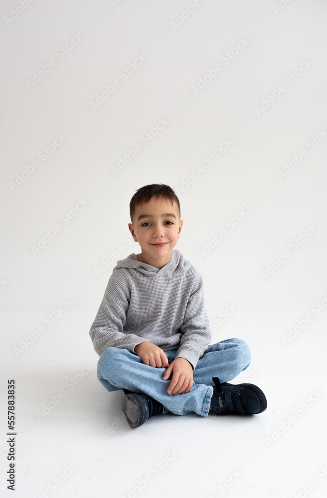 Boy child preschooler smiling and posing on gray background in photo studio Boy child preschooler smiling and posing on gray background in photo studio