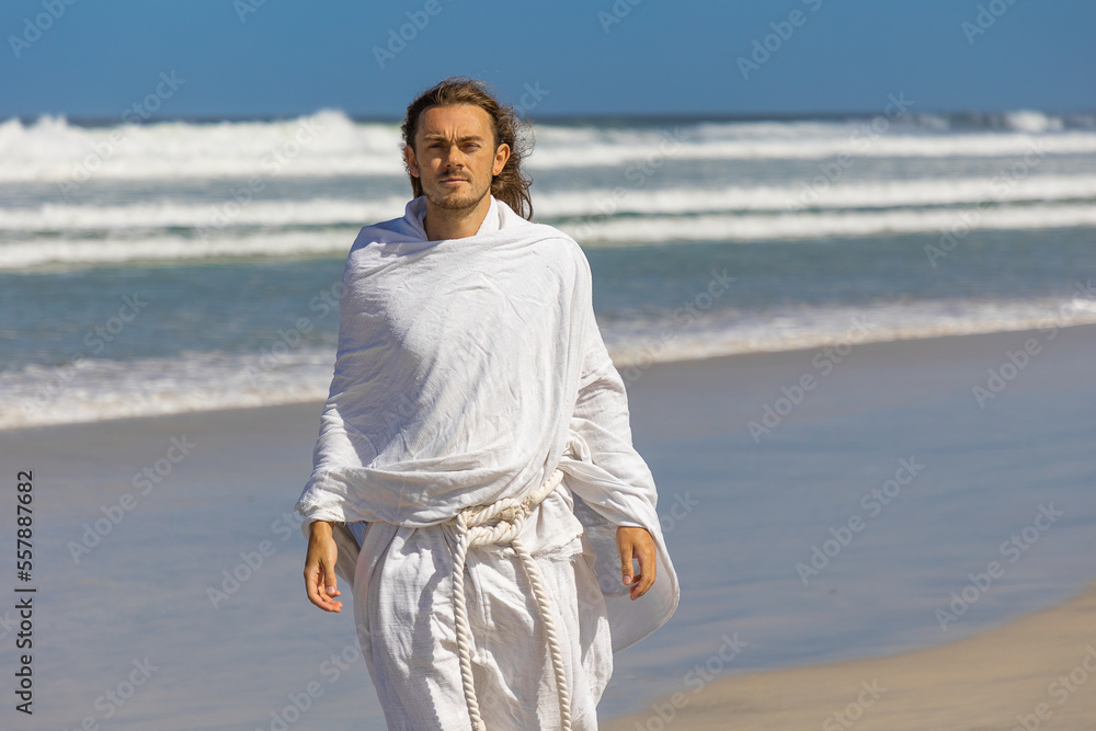 Religious image of man in white robe with beard next to sea (of Galilee)