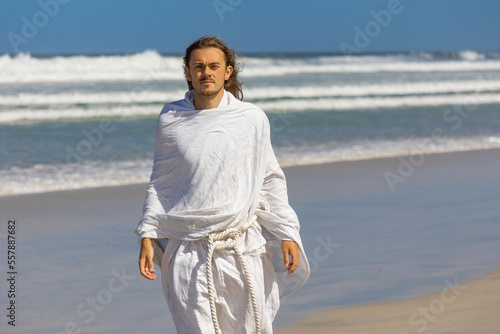 Obraz na płótnie Religious image of man in white robe with beard next to sea (of Galilee) w salonie