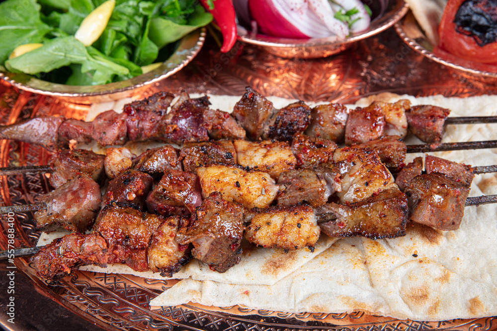 Liver kebab, one of Adana's special tastes. street flavors. Grilled beef liver on skewers, with teriyaki or soy sauce. Ciger kebab, table, liver on skewers.
