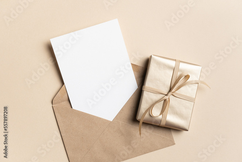 Greeting card mockup with envelope and golden gift box, copy space