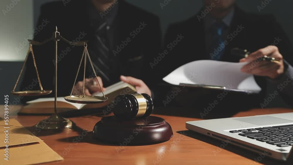 Business and lawyers discussing contract papers with brass scale on desk in office. Law, legal services, advice, justice and law concept picture with film grain effect Business and lawyers discussing contract papers with brass scale on desk in office. Law, legal services, advice, justice and law concept picture with film grain effect