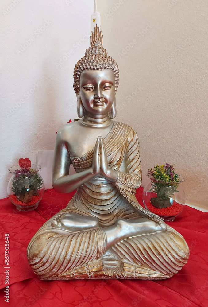 Buddha image on top of a red towel with 2 vases beside it Buddha image on top of a red towel with 2 vases beside it