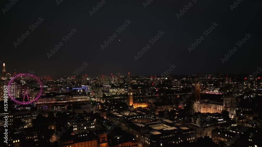 Aerial Panoramic Helicopter View Of City of London Skyline Palace of Westminster Big Ben The London Eye Wheel And Thames River Purple Illuminated at Night Aerial Panoramic Helicopter View Of City of London Skyline Palace of Westminster Big Ben The London Eye Wheel And Thames River Purple Illuminated at Night