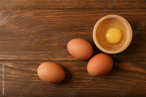 Raw chicken eggs on wooden table, flat lay. Space for text