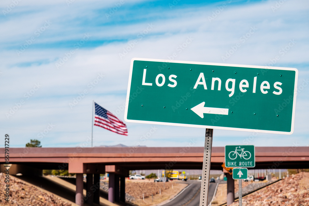 Road sign pointing to Los Angeles with USA flag in the background. California, USA Road sign pointing to Los Angeles with USA flag in the background. California, USA