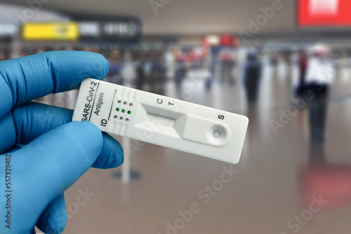 Airport checkpoint worker with covid or Coronavirus antigen diagnostic test device for diagnostic in tourists. doctor holding COVID-19 or sars-cov-2 virus disease rapid swab test to travelers on inter
