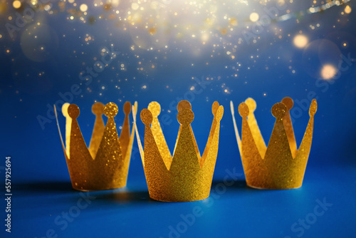 Leinwand Poster Happy Epiphany Day, Three Kings Day greeting card with three gold crowns on blue background