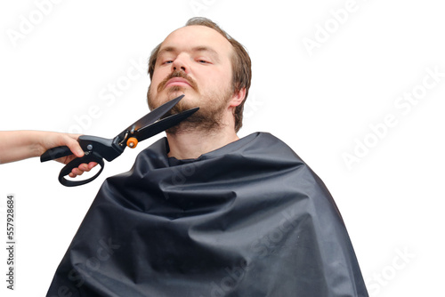 Wife cuts her husband's beard with large garden scissors, copy space, isolated on a white background. Concept of self-cutting and shaving during the flu epidemic