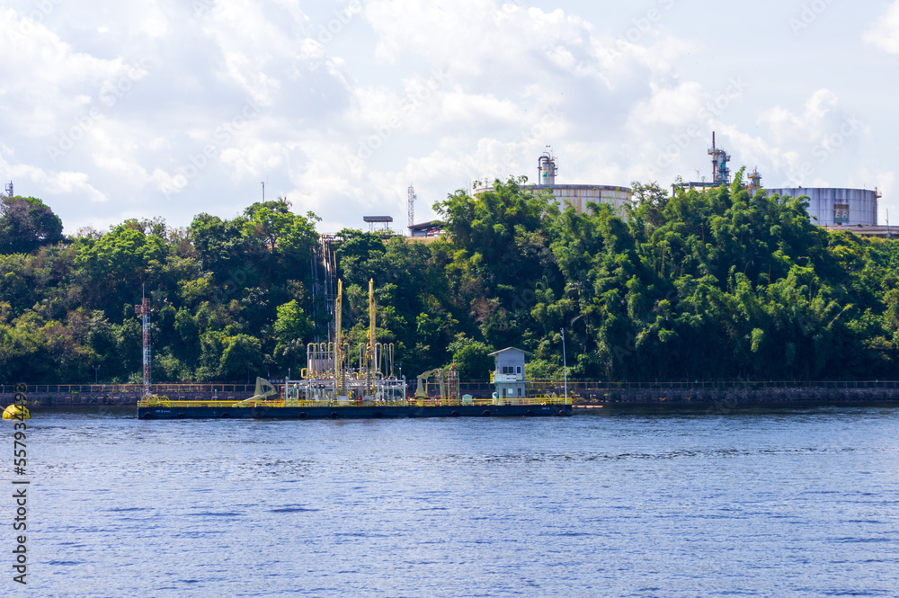 Fototapeta premium Industrial site on the river banks of Rio Amazonas in Brazil surrounded by the green rainforest