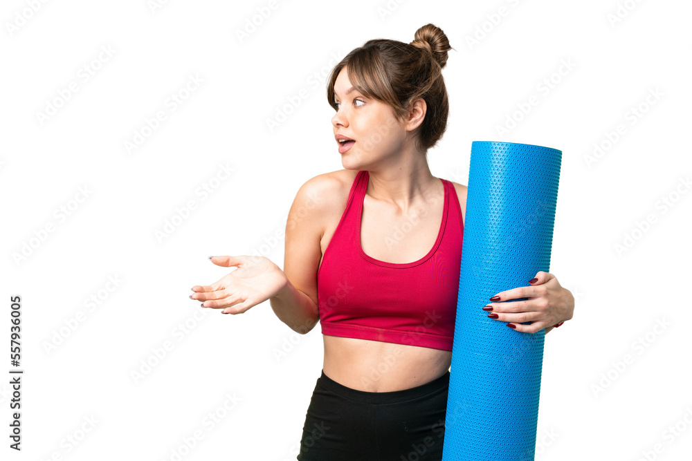 Young sport girl going to yoga classes while holding a mat over isolated chroma key background with surprise expression while looking side Young sport girl going to yoga classes while holding a mat over isolated chroma key background with surprise expression while looking side