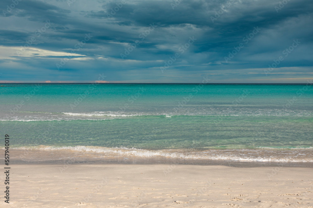 San Teodoro sand beach with turquoise sea water in Sadinia Italy, clouds in the sky during summer