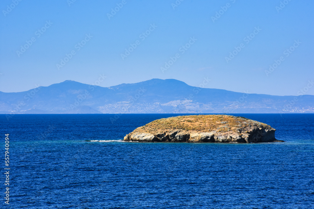 A Small islet, cliffs, mountain and bay view in the virgin bays of İzmir Foça. Virgin coves of the Aegean Sea. Phokaia, Izmir Bays.The view of the Karaburun mountains and the Aegean Gulf from Foça. A Small islet, cliffs, mountain and bay view in the virgin bays of İzmir Foça. Virgin coves of the Aegean Sea. Phokaia, Izmir Bays.The view of the Karaburun mountains and the Aegean Gulf from Foça.
