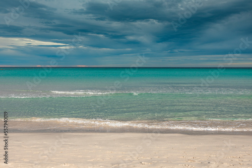 San Teodoro sand beach with turquoise sea water in Sadinia Italy, clouds in the sky during summer