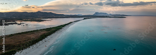 San Teodoro sand beach with lagoon  mountain of island Tavolara and coastline in Sadinia Italy from above during sunset  clouds in sky