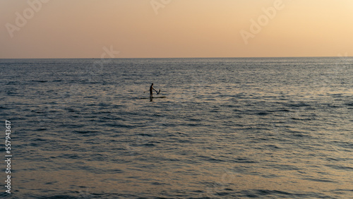 person on surfboard in the middle of the sea at sunset in huatulco beach oaxaca, mexico © IVAN
