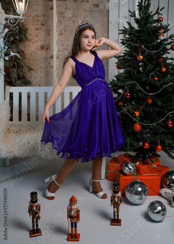 studio portrait of a girl near a bench and a Christmas tree photo