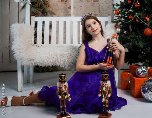 studio portrait of a girl near a bench and a Christmas tree photo