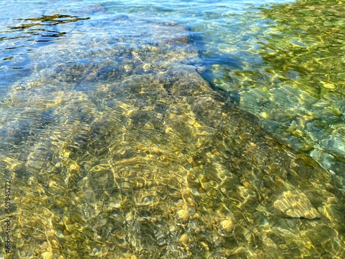 Gravel pebbles beach. Crystal clear sea water. Transparent calm sea.