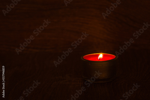 Close-up lighting a candle with a match in the dark