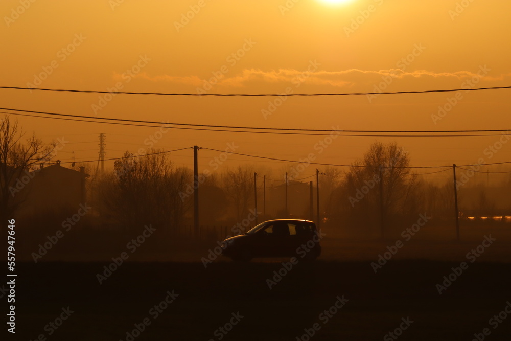 Utility car on the road during winter sunset with haze