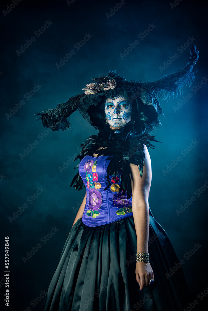 Mexican catrina woman dressed in talavera type costume in blue colors with feather hat and pearl necklace, represents the day of the dead part of the traditions of November 1