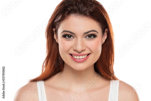 beautiful young smiling redhead women with makeup and long hair on a white background.