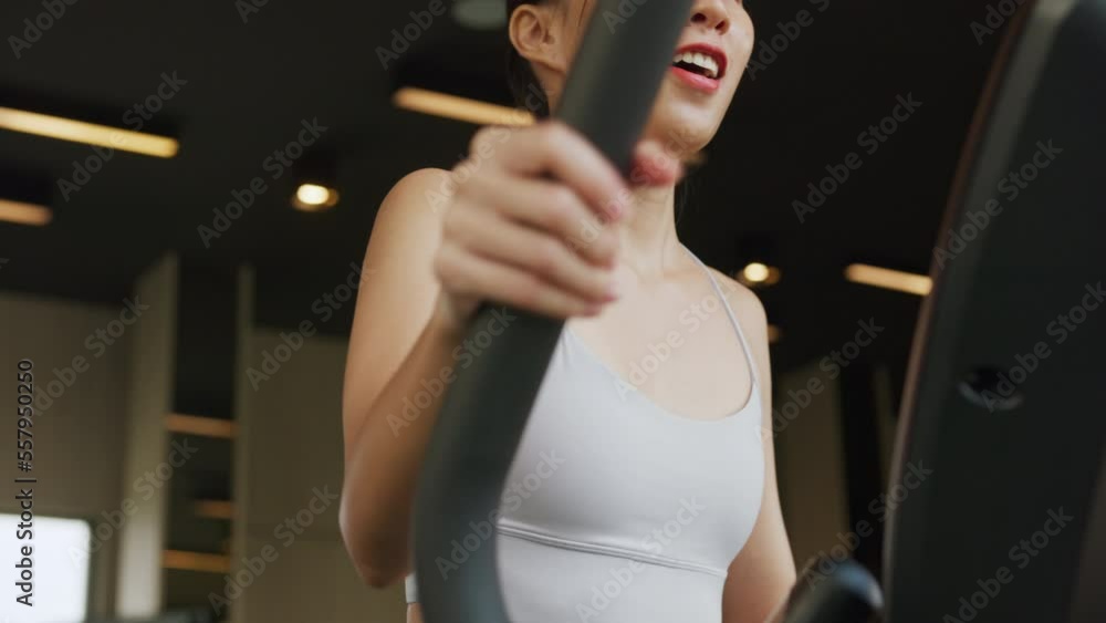 Closeup attractive female in sportswear on xtrainer machine cardio for