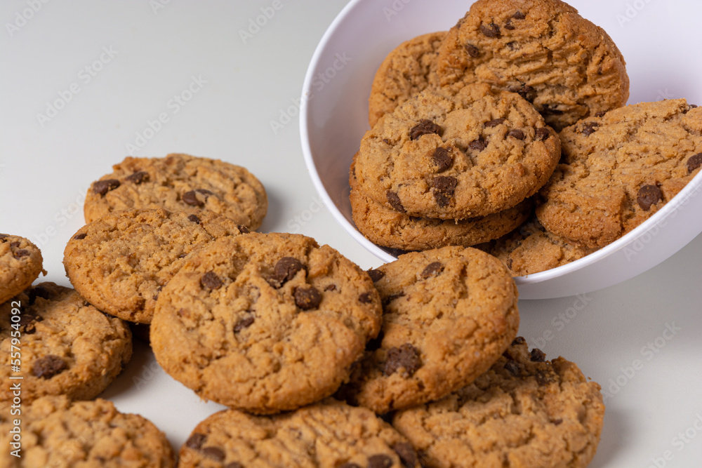 cookies falling from bowl on the table, isolated on white background cookies falling from bowl on the table, isolated on white background