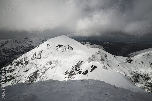 Wędrówka górska zaśnieżoną granią. Tatry polskie i słowackie. Zmienna pogoda z dynamicznie wyglądającymi chmurami. © ErOn