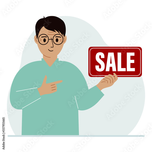 A man holds a banner with the text sale. Points a finger at the text. The concept of a discount, a special offer in a store or a bank, an advertising flyer.