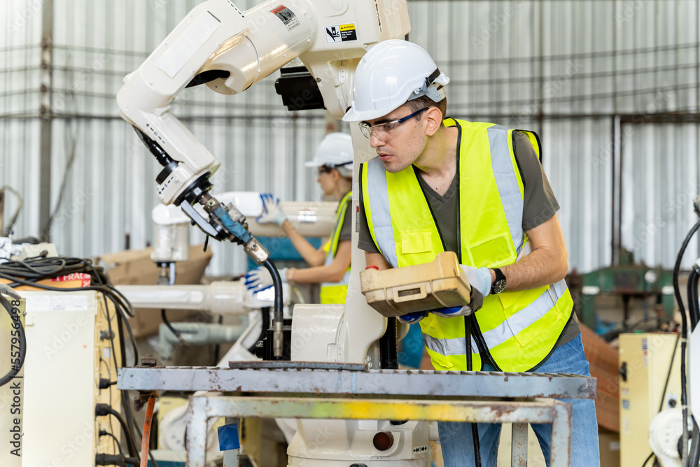 A team of male and female engineers meeting to inspect computer-controlled steel welding robots. Plan for rehearsals and installation for use. A team of male and female engineers meeting to inspect computer-controlled steel welding robots. Plan for rehearsals and installation for use.