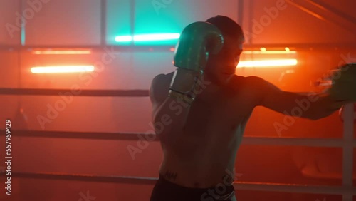 Boxer in the boxing gym. Bandages his hands. Sparring in the ring. Boxer jumping rope. Exercise with ropes. Round one. Fog in the ring. Zetsky sport. Beautiful backlight. World boxing champion.

 photo