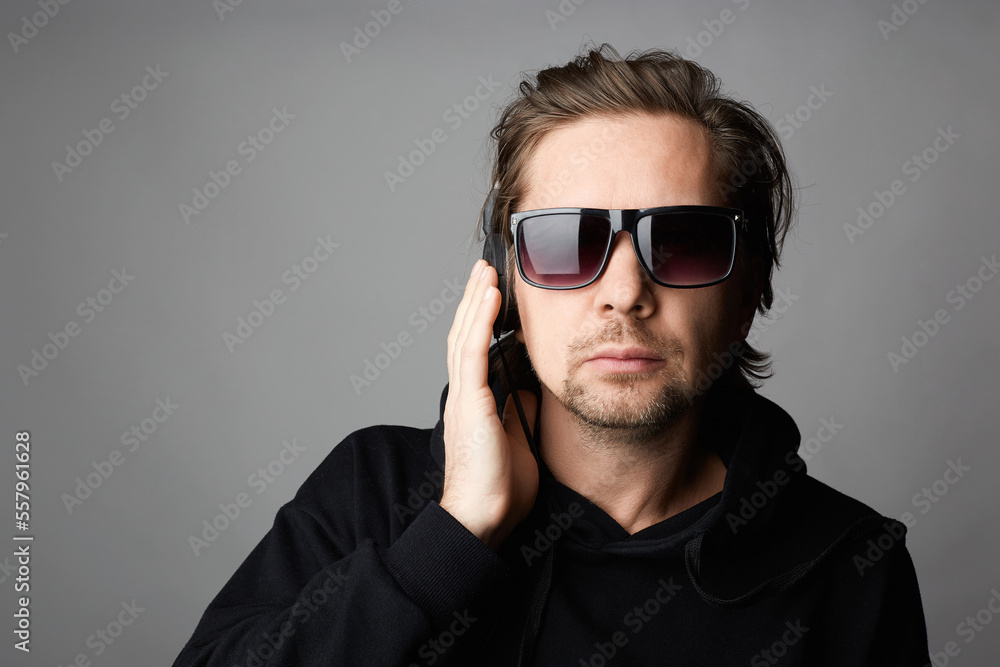 DJ with headphones and sunglasses. Man in hoodie DJ with headphones and sunglasses. Man in hoodie