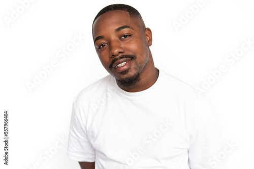 Pleased African American man smiling. Portrait of curious young male model with short hair in white T-shirt looking at camera, tilting head with proud look. Success concept