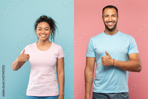 Excited african american spouses showing their thumbs up and smiling on pink and blue studio background