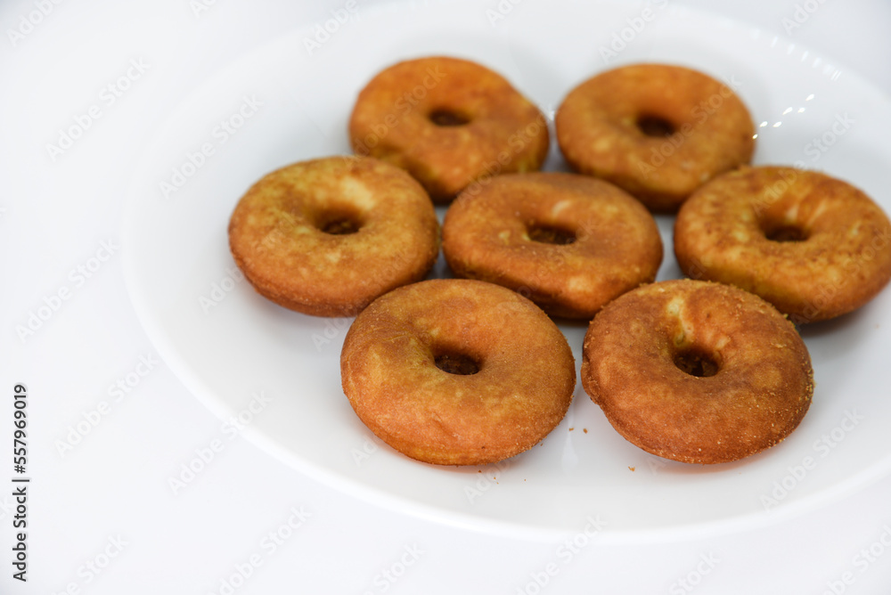 Round shortbread cookies on a plate. Soft sweet cake on a white background. A sweet snack. Round shortbread cookies on a plate. Soft sweet cake on a white background. A sweet snack.