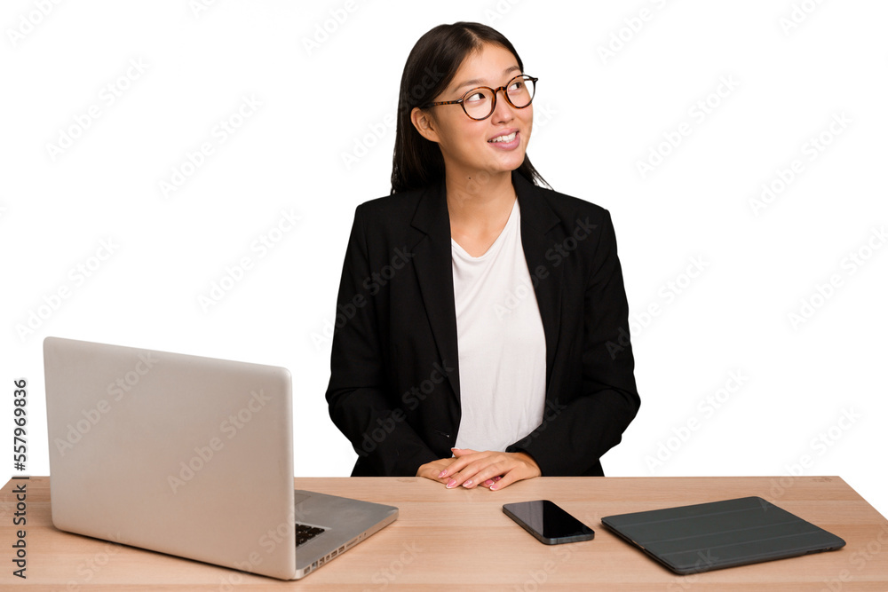 Young business asian woman sitting on a table isolated relaxed and happy laughing, neck stretched showing teeth. Young business asian woman sitting on a table isolated relaxed and happy laughing, neck stretched showing teeth.