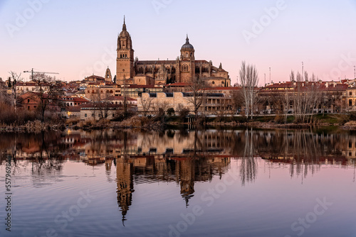 Scenic urban landscape of the city of Salamanca at sunset with the cathedral reflected in the Tormes river. Castilla Leon, Spain
