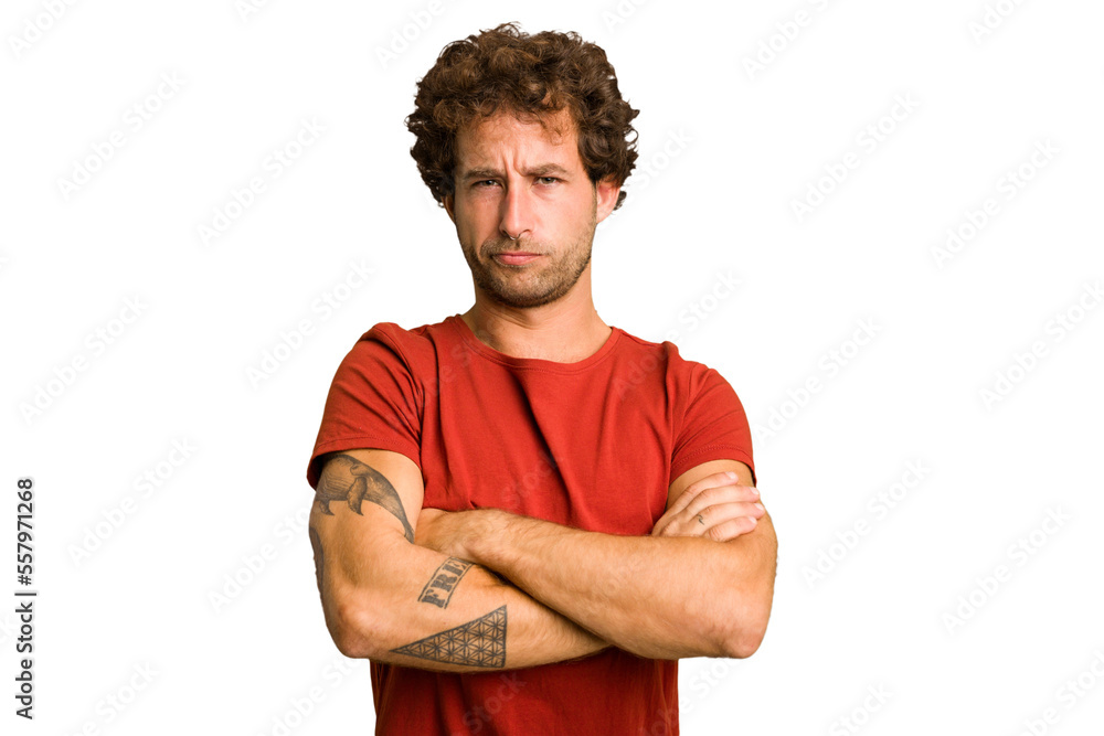 Young curly smart caucasian man cut out isolated frowning face in displeasure, keeps arms folded.
