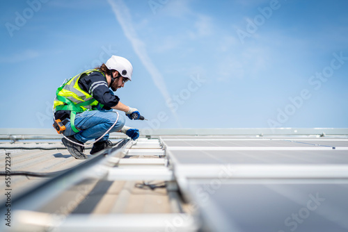 Male engineer installing or checking the working condition of solar panels on the roof or at the height of the factory for saving electricity was broken to use renewable energy from the sun