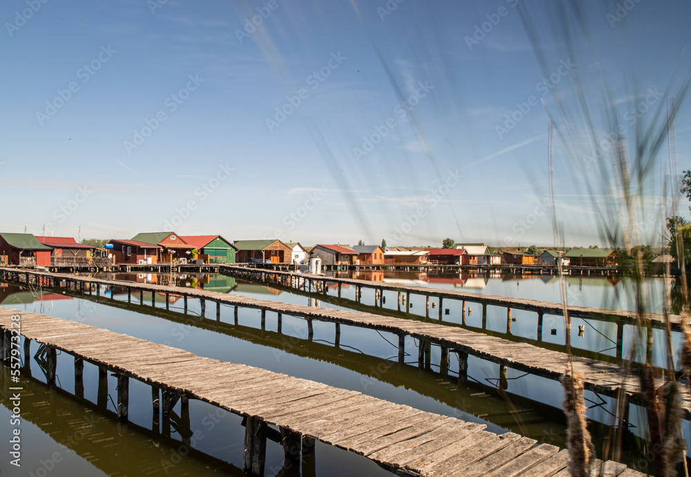 Oriental village on a canal. Houses on stilts. Flooded houses Floating village. Paths on water