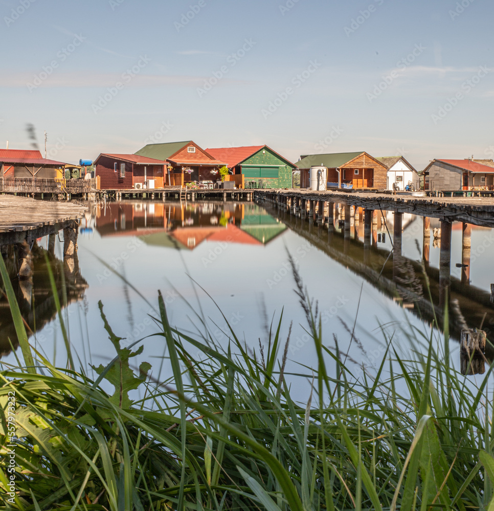 Home on stilts, Living on water flooded village, Bokodi Hutoto, Hungary, Clear sky. Wooden piers, 