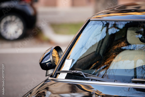 City scene with car parked with parking fine on the windshield