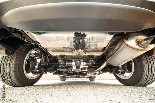 Auto mechanic view of bottom of the car. Rear differential axle wide angle, rear suspension system and components of exhaust system in passenger city car. All wheel drive system vehicle.