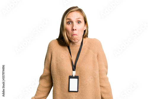 Obraz na plátne Young caucasian woman with ID card isolated shrugs shoulders and open eyes confused