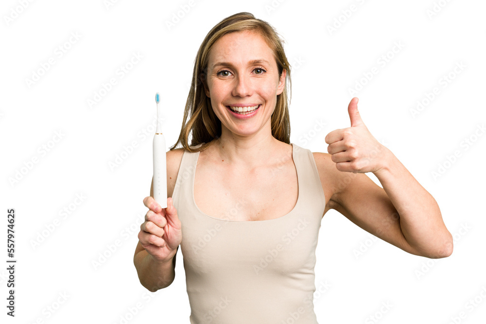 Young caucasian holding a brushing teeth isolated smiling and raising thumb up Young caucasian holding a brushing teeth isolated smiling and raising thumb up