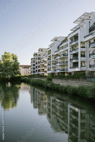 Modern apartment building condominium real estate by the lake with large reflection in the clear still water
