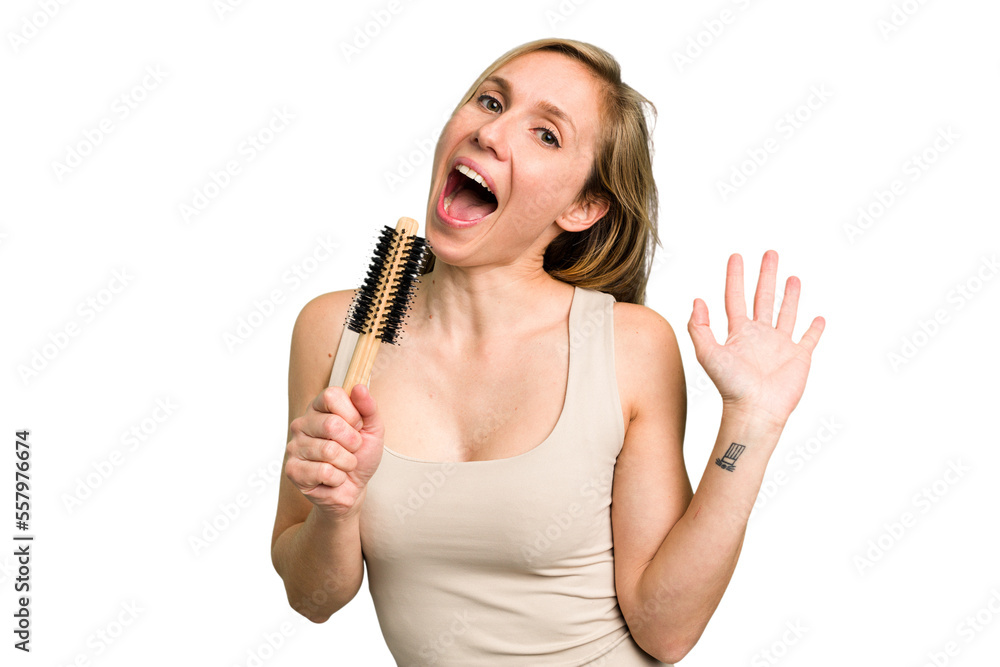 Young caucasian woman using an hair comb isolated Young caucasian woman using an hair comb isolated
