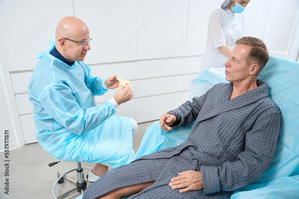 Calm patient and professional medic having talk before starting treatment Calm patient and professional medic having talk before starting treatment